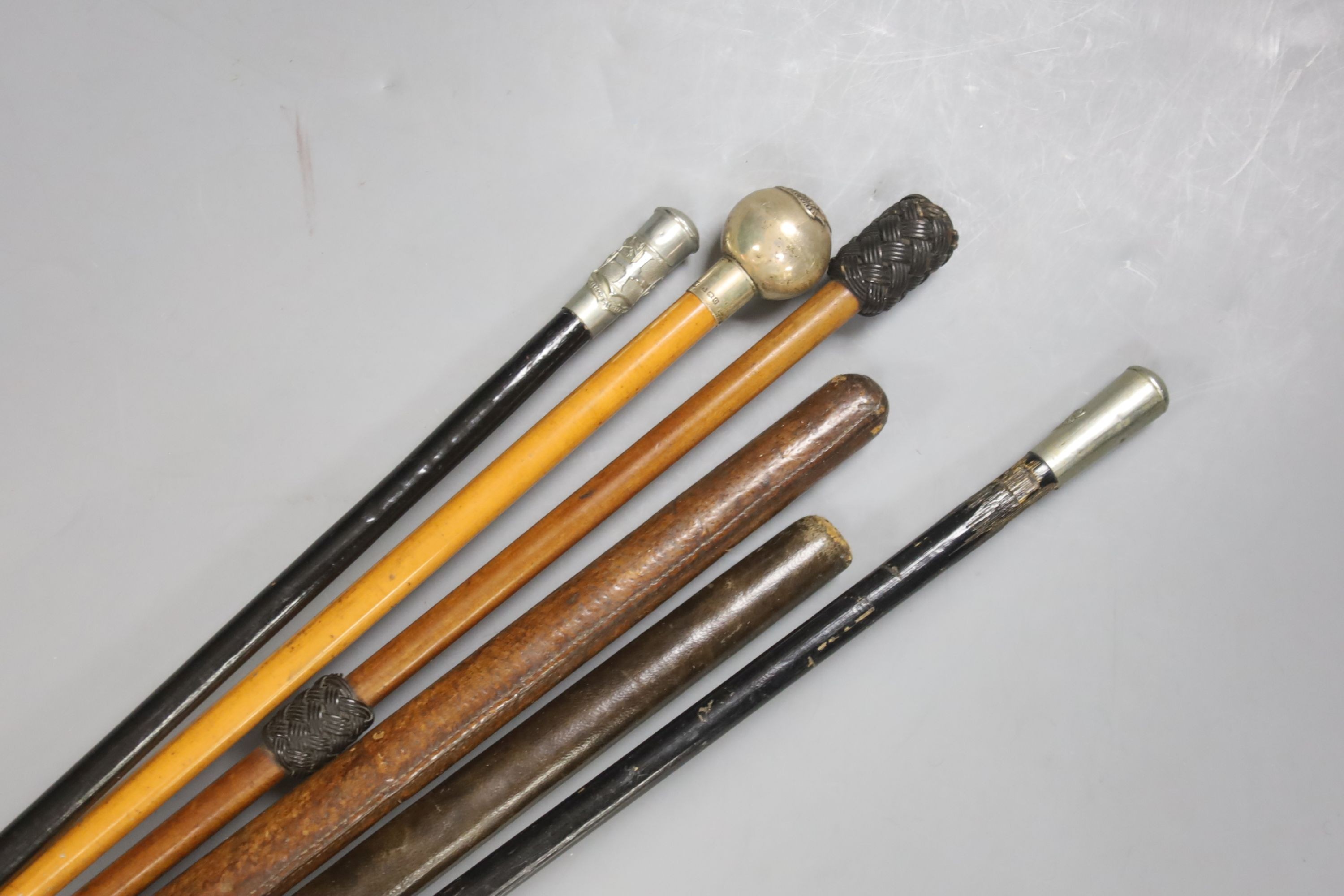 A silver topped RAMC swagger stick, a leather stiletto swagger stick and four other swagger sticks or riding sticks